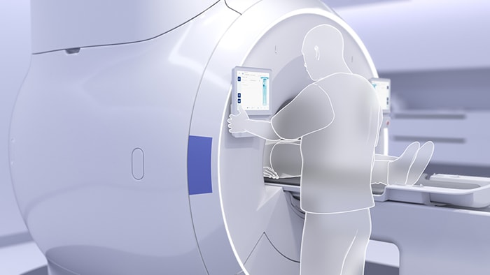 MRIタッチスクリーンを使用してワンタッチオートスタートを実行する技師の写真 image