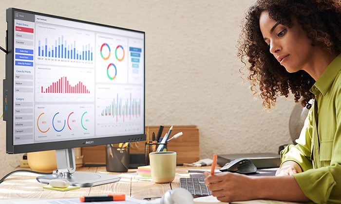 A woman is working with the tco edge certified Philips Monitors